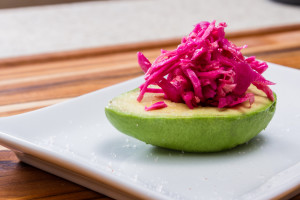 serving of fermented or cultured purple cabbage paired with an avocado on a white plate